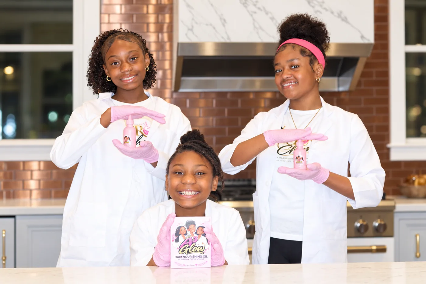 Aubree, Avery, and Ashley holding A³Glow Hair Nourishing Oil